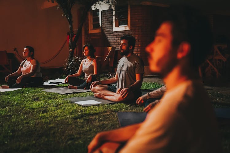 People Practicing Yoga Outdoors On Sunset