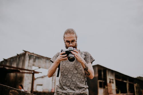 A Bearded Man Holding a Camera 