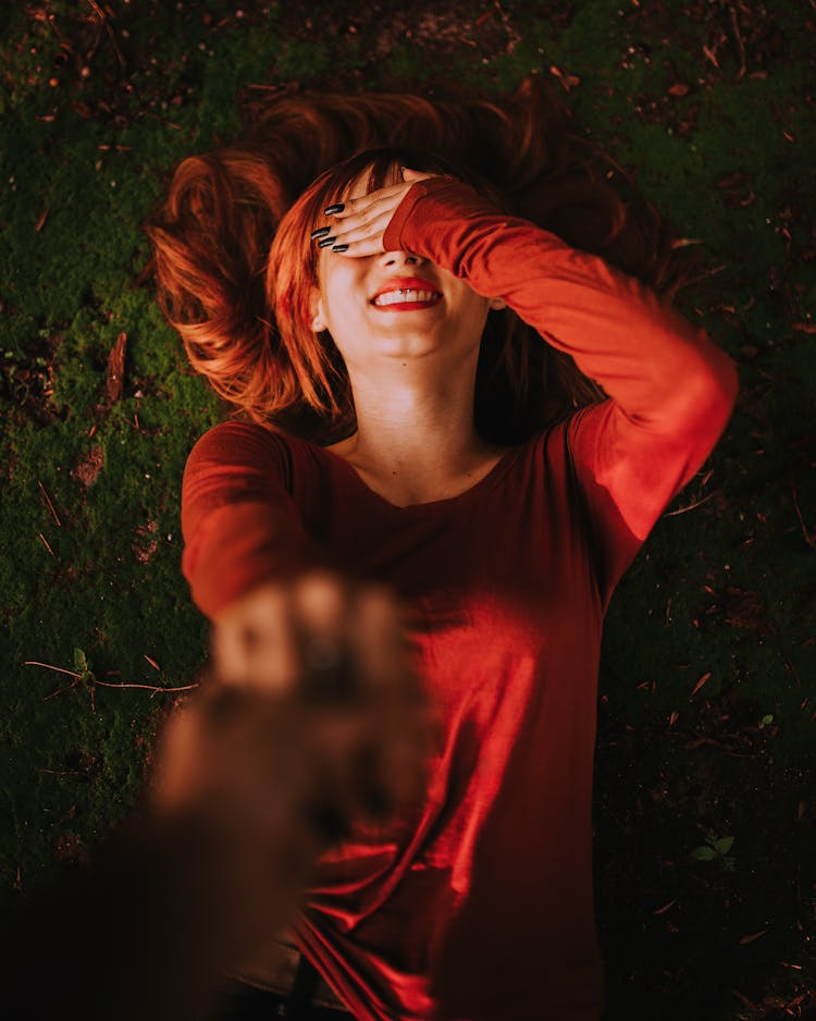 Woman Lying On The Ground With Hand Over Her Eyes 