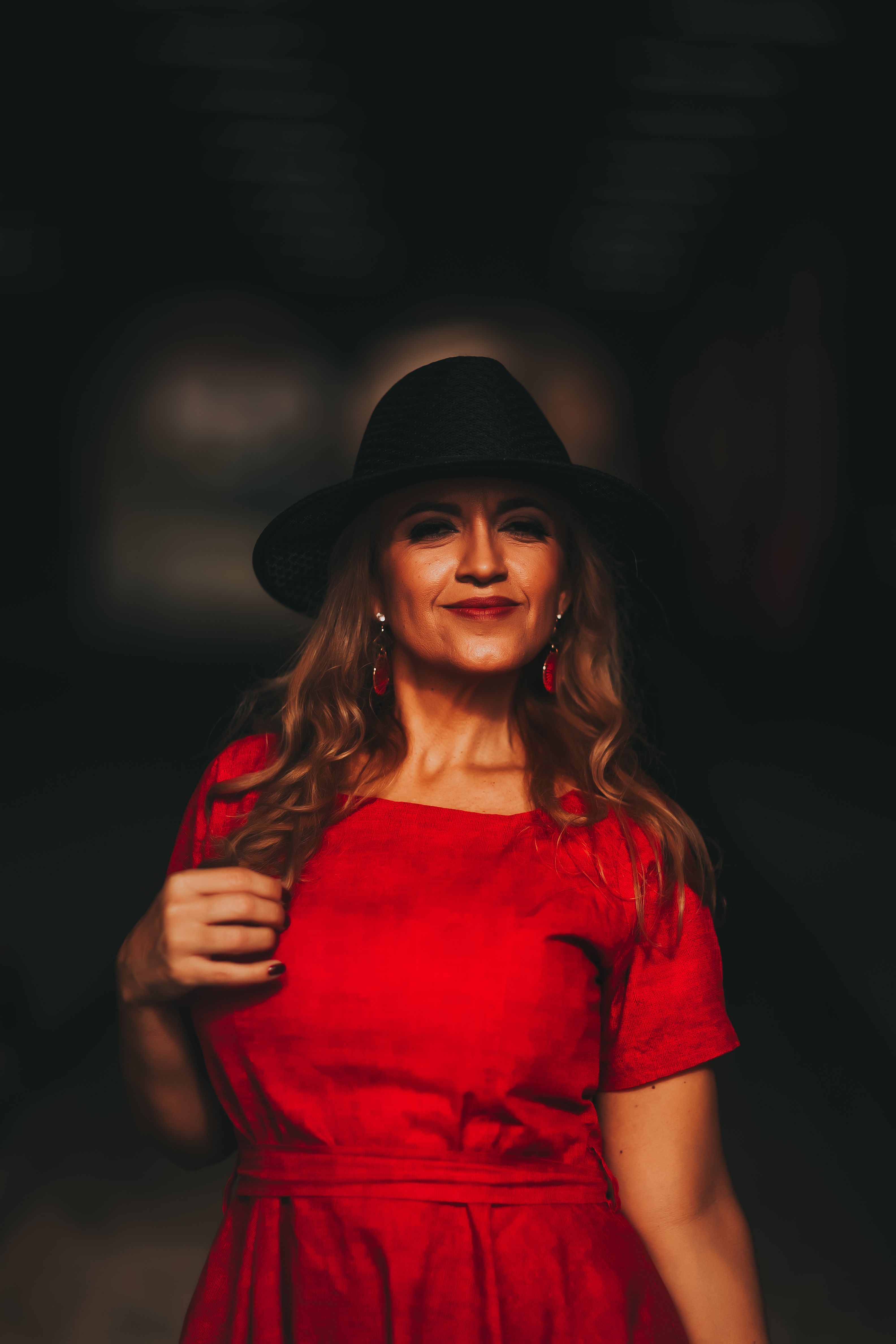 Close-Up Shot of a Woman in Red Dress Wearing Black Hat · Free Stock Photo