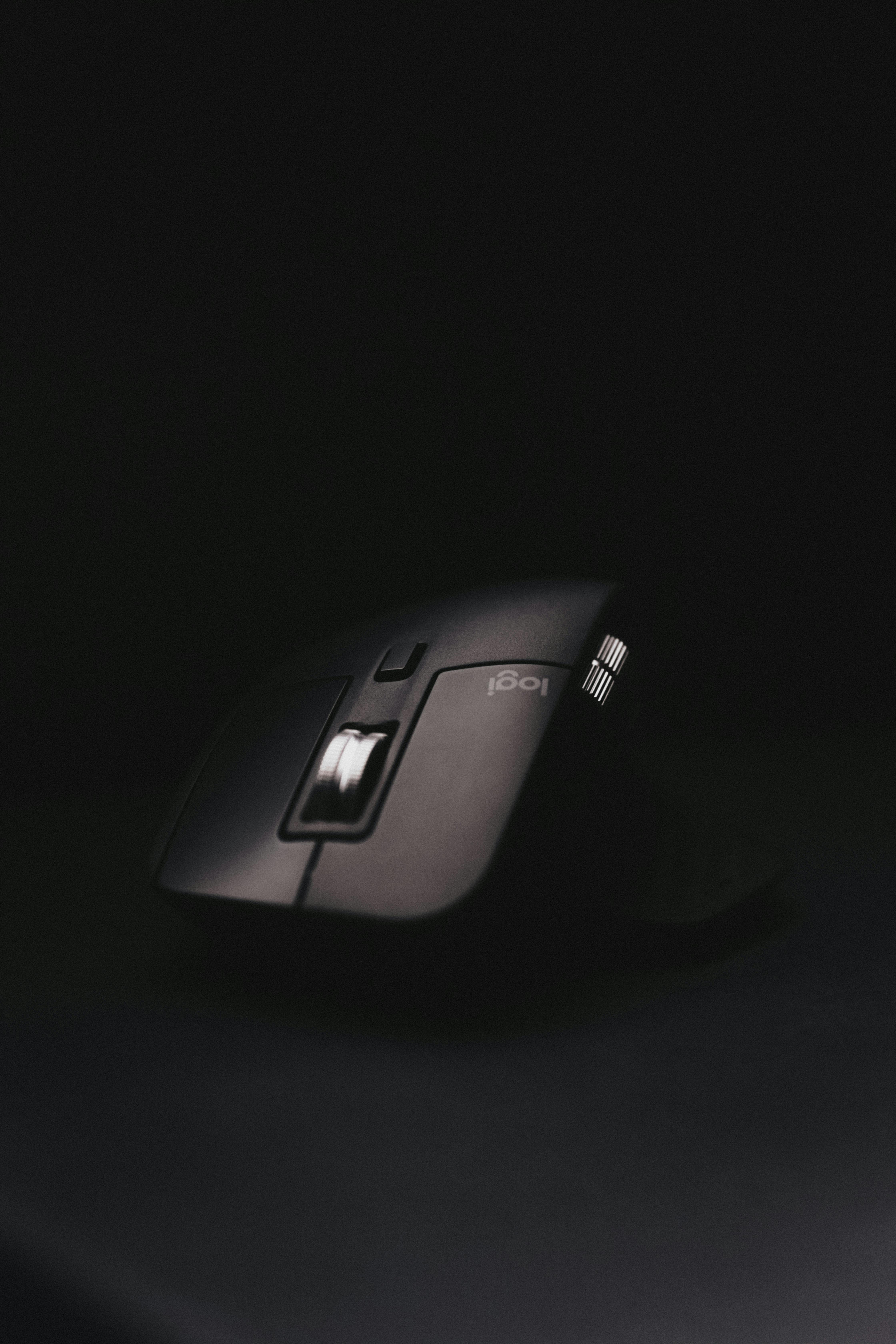 Free Close-up of a black computer mouse with illuminated scroll wheel on a dark background. Stock Photo