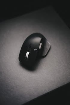 A sleek, ergonomic wireless computer mouse displayed on a black surface, emphasizing modern design.