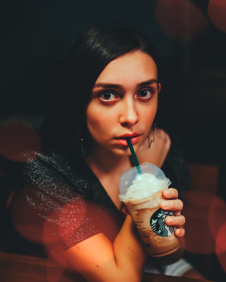 A Young Woman Sipping Iced Coffee