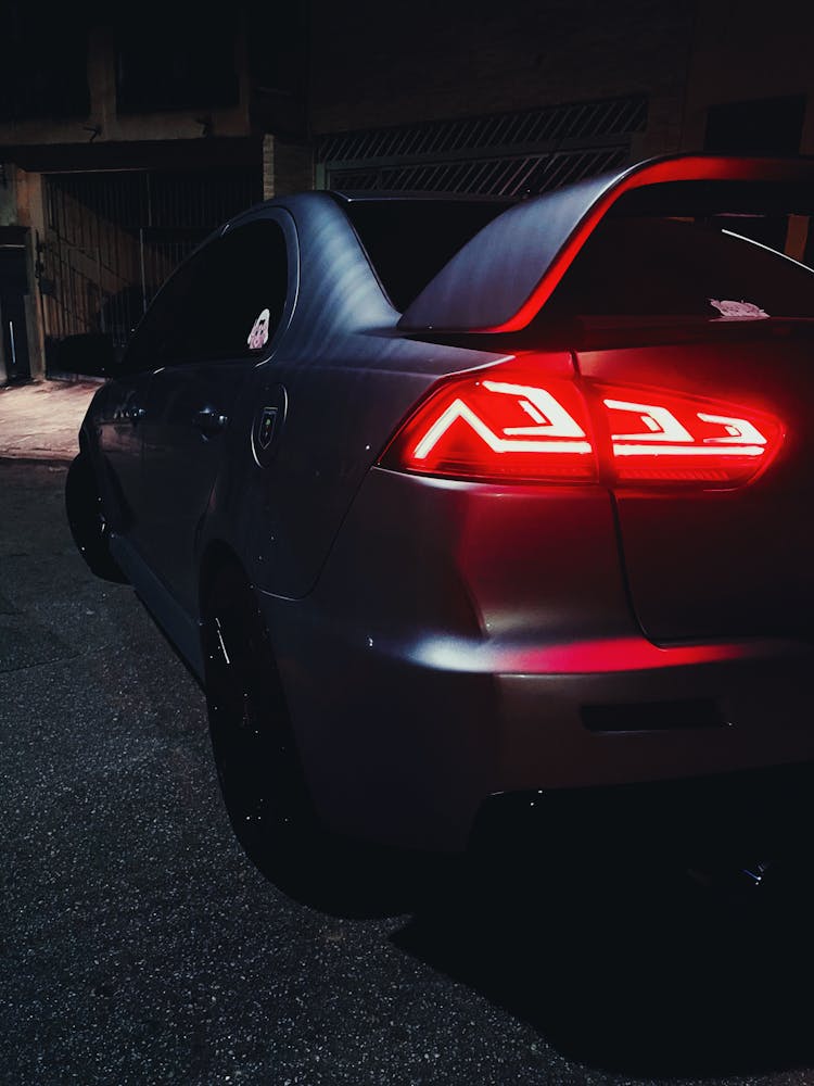 Back View Of A Black Sports Car With Red Light