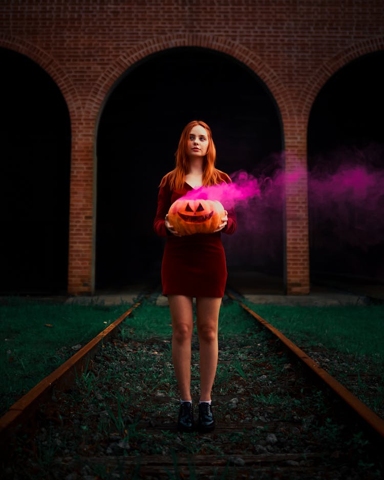 Woman Holding Pumpkin With Purple Smoke