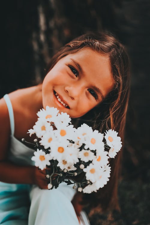 Close-Up Shot of a Girl Holding White Flowers