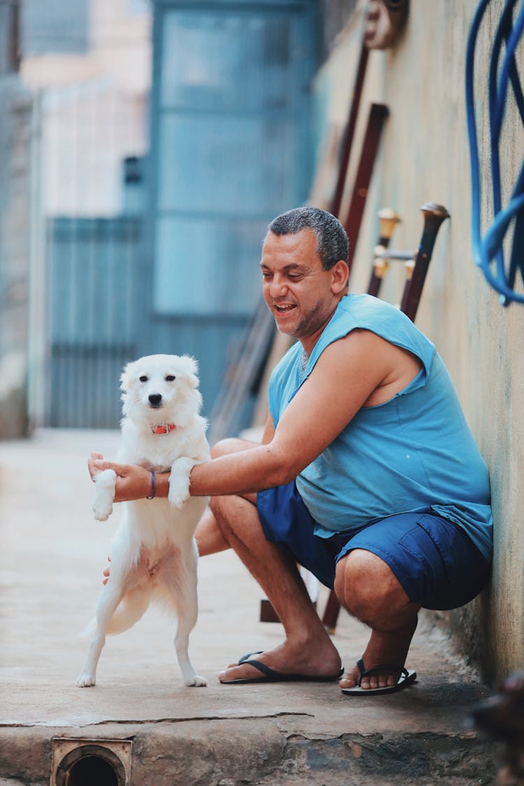 A Man Holding The White Dog