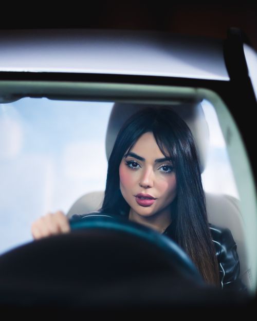 Free Portrait of a young woman in a car, focused and confident. Stock Photo