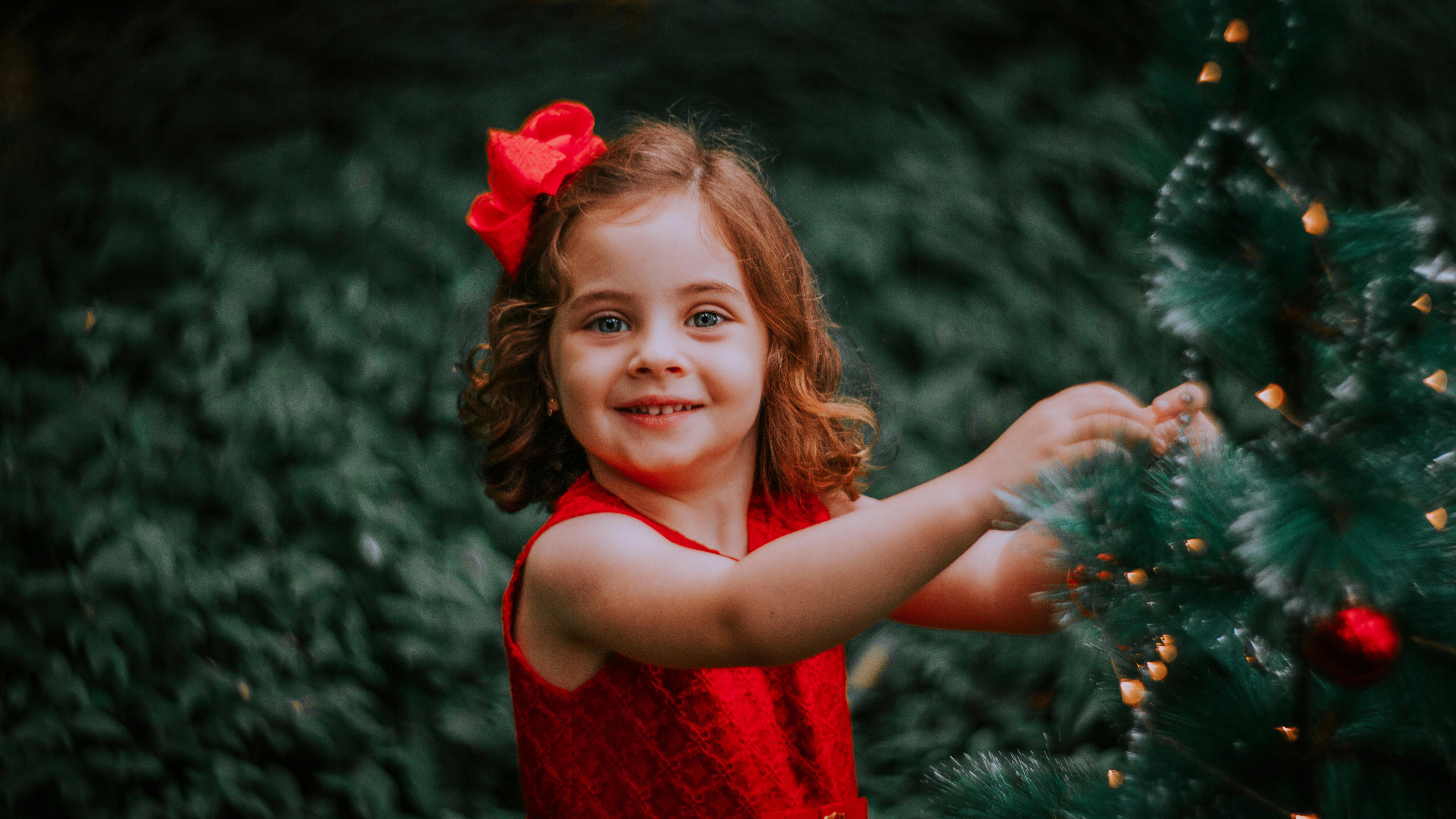 pretty girl hanging decoration on christmas tree