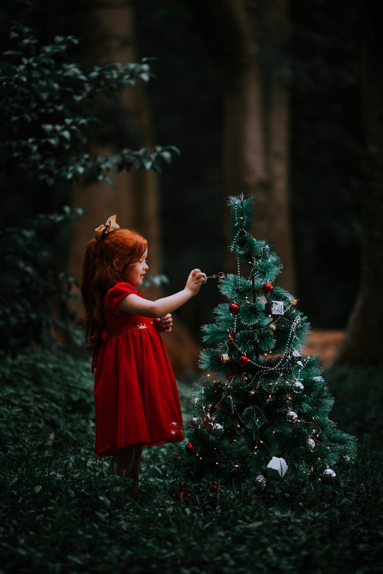 Girl In Dress Decorating Christmas Tree