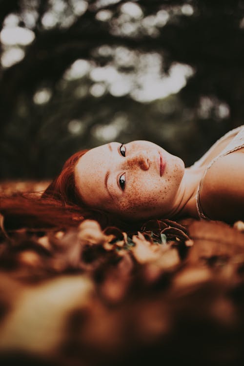 Redhead Woman Lying on Fall Ground