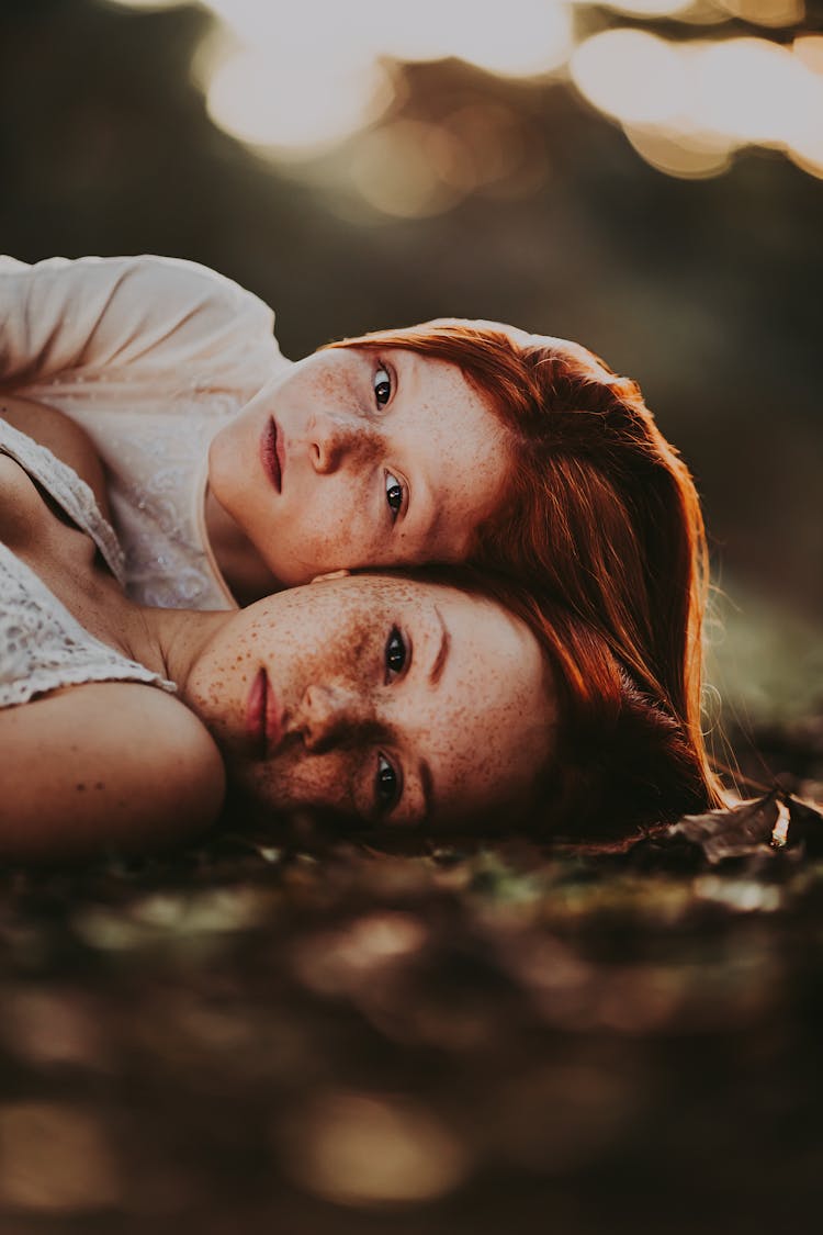 Redhead Girls Lying On Ground In Forest