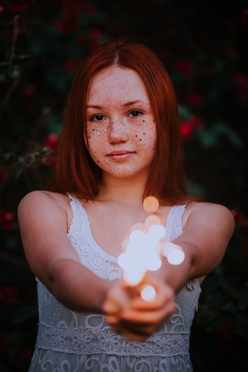 A Woman with Freckles Holding Fairy Lights