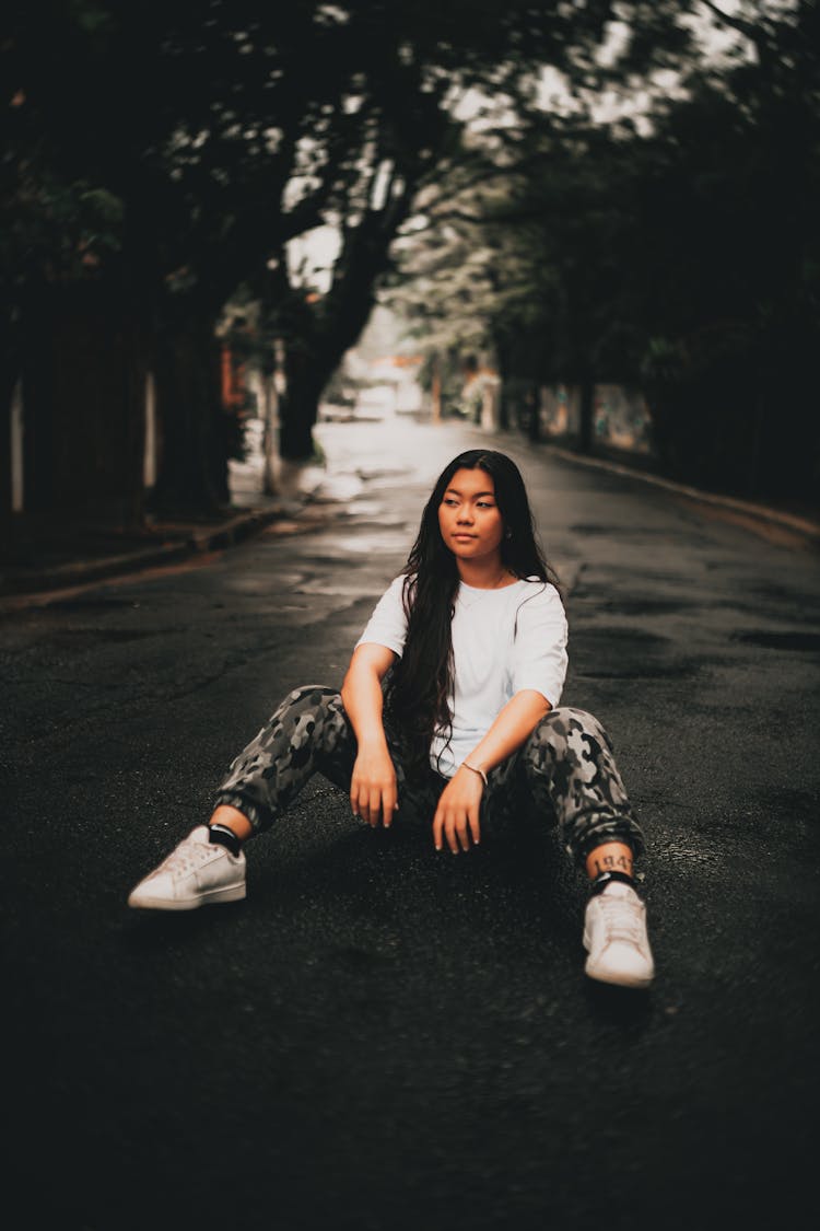 Woman In Casual Clothes Sitting On Road