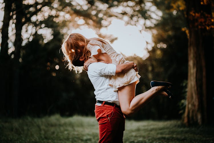 Man Holding Woman In Arms In Park