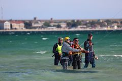 Beginner kitesurfer learning over flat shallow water with instructor nearby