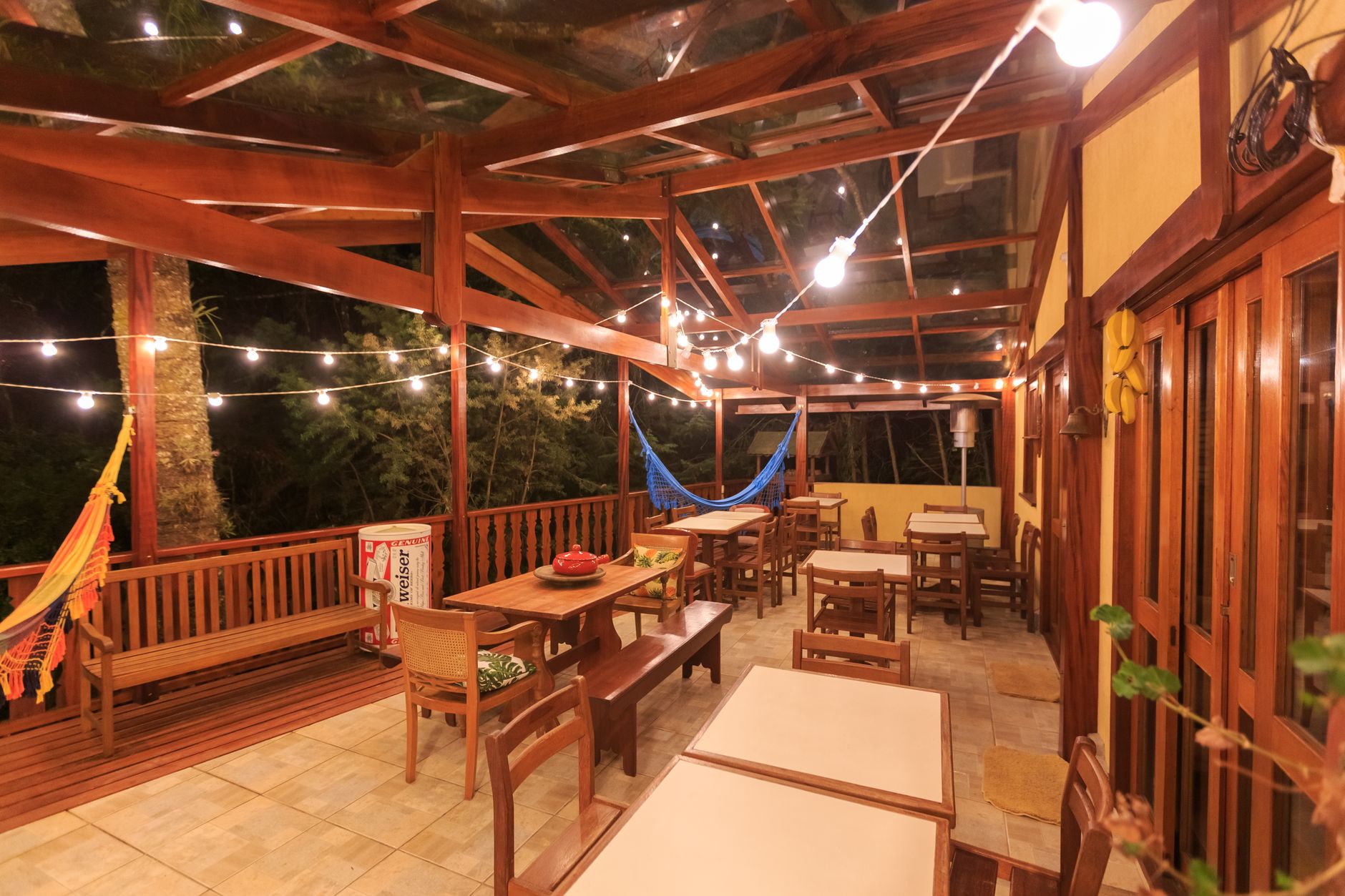 Charming outdoor patio area illuminated at night with string lights and hammock.