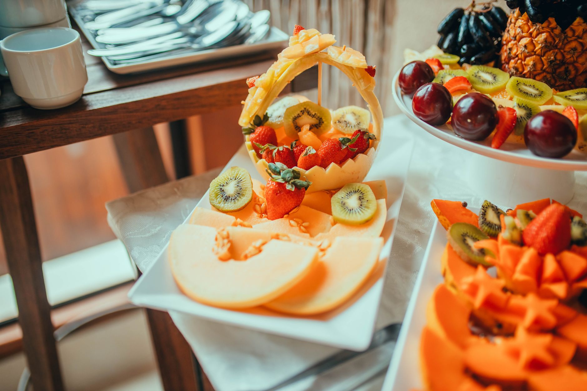 Vibrant platter of assorted fresh fruits including melons, strawberries, and kiwis, beautifully arranged.
