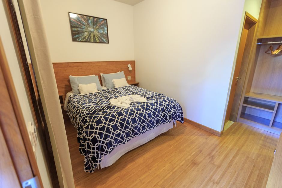 Fotomural Habitación elegante y minimalista con una cama cómoda y suelo de madera.