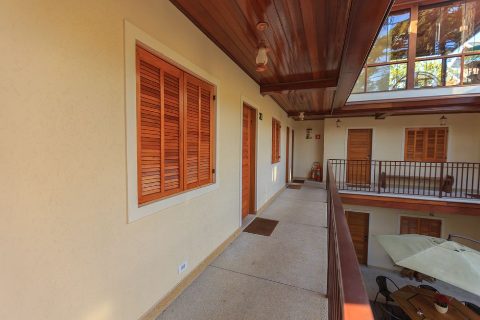 Pátio espaçoso de hotel de luxo com portas de madeira e design minimalista, refletindo tendências arquitetônicas modernas.