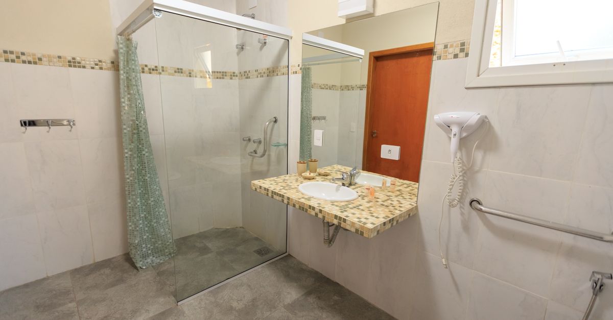 Spacious and accessible bathroom featuring a large glass shower, modern sink, and stylish decor.