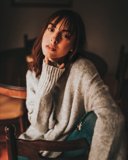 Woman in a Sweater Sitting on a Chair