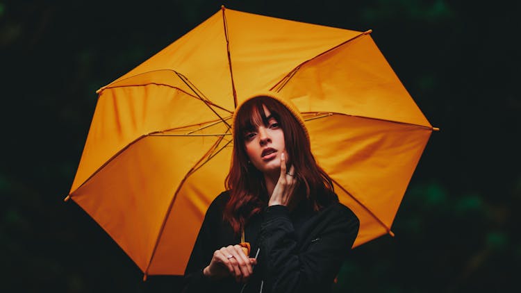 Woman Holding An Umbrella With A Hand On Her Face