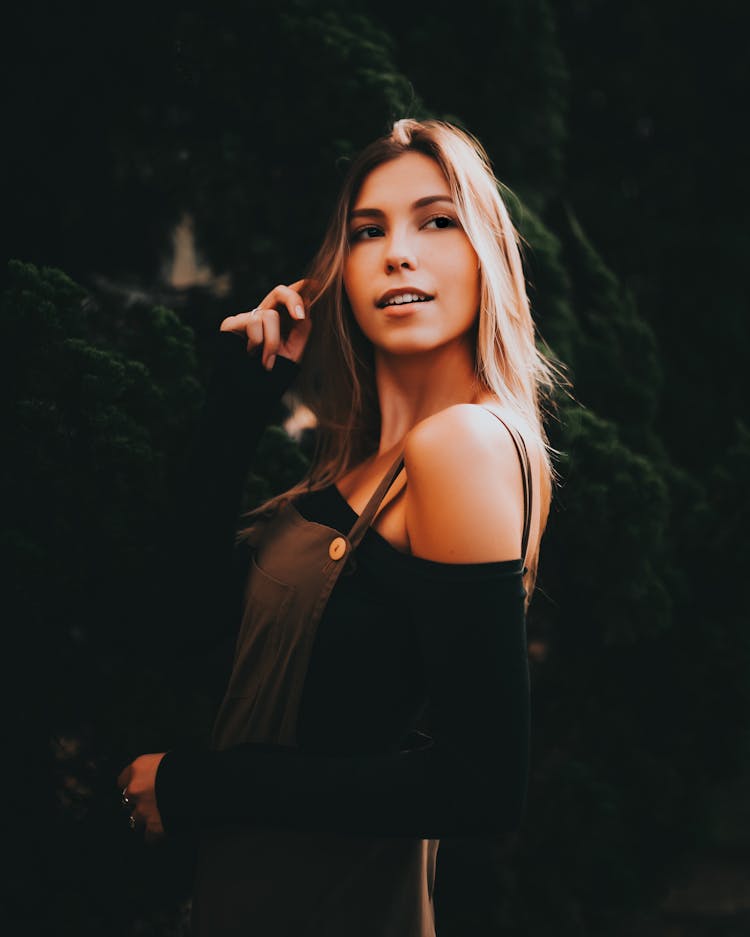 Woman Smiling With A Hand Twirling Her Hair