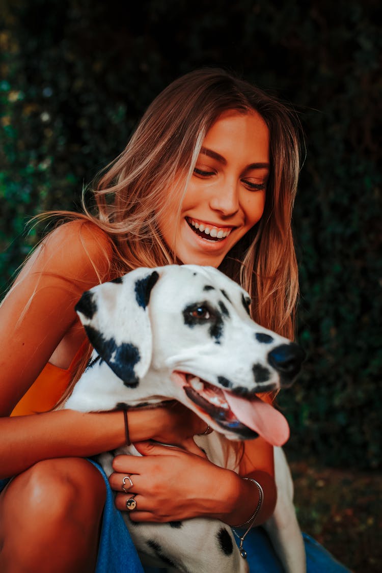 Woman Holding Her Dalmatian And Laughing