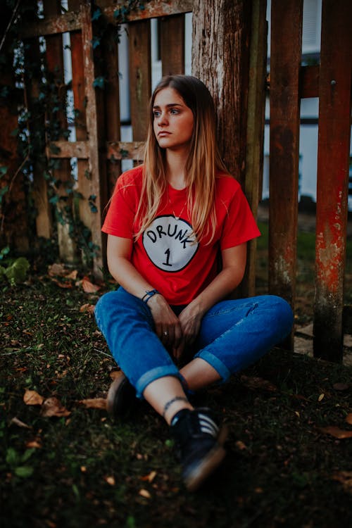 Woman Sitting next to Fence