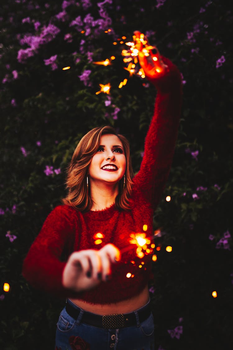 Young Woman Playing With Sparklers In Hands