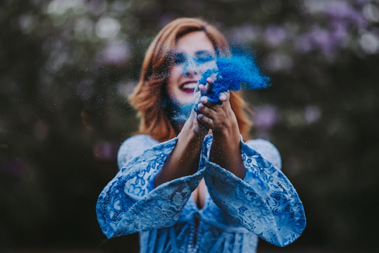 Smiling Woman Scattering Blue Powder