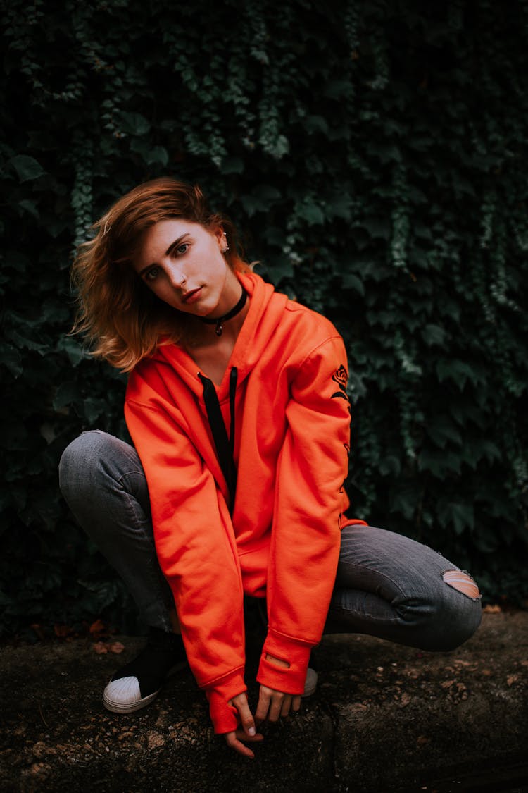 Teenage Girl Posing In Torn Jeans And Orange Blouse