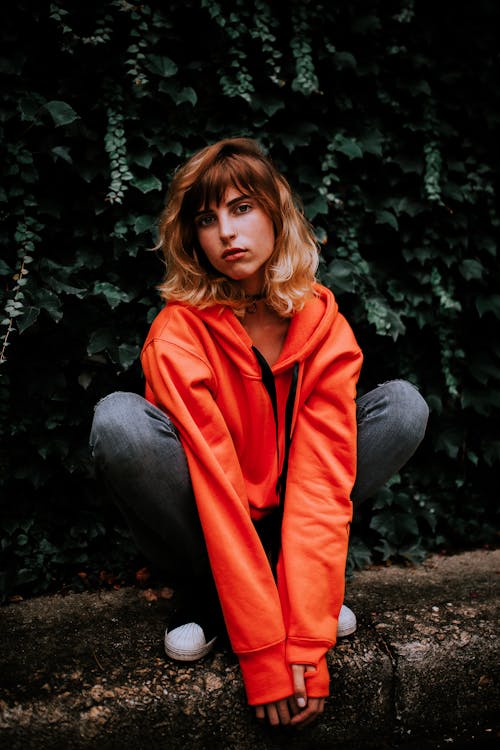 Young Woman in Orange Hoodie Young with Arms Down