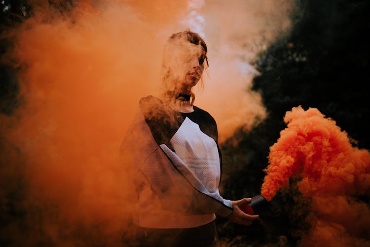 A Woman Holding A Smoke Bomb