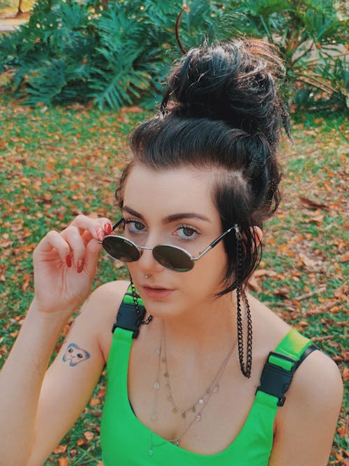 Young Woman Looking from under Her Sunglasses 