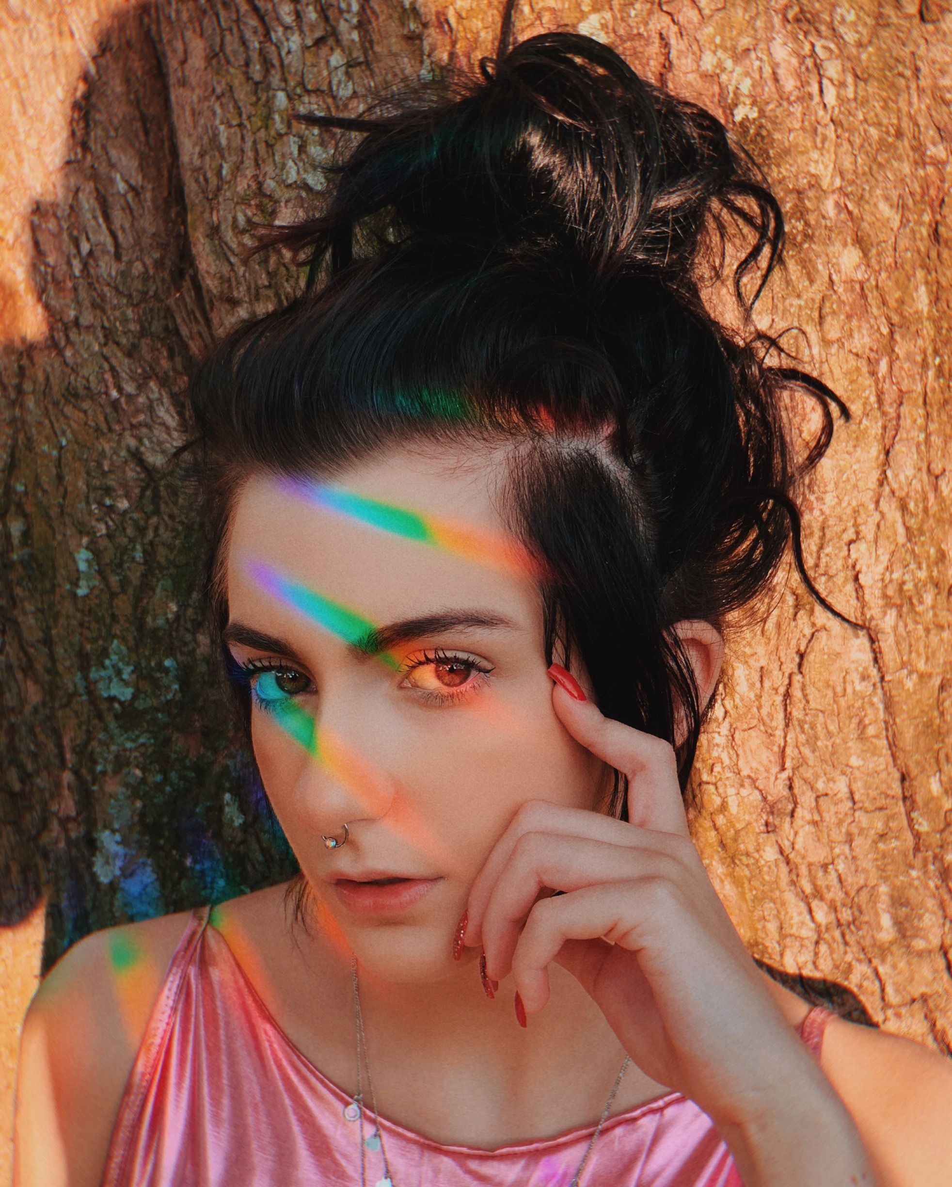 Colorful portrait of a woman under rainbow light creating an artistic visual effect.