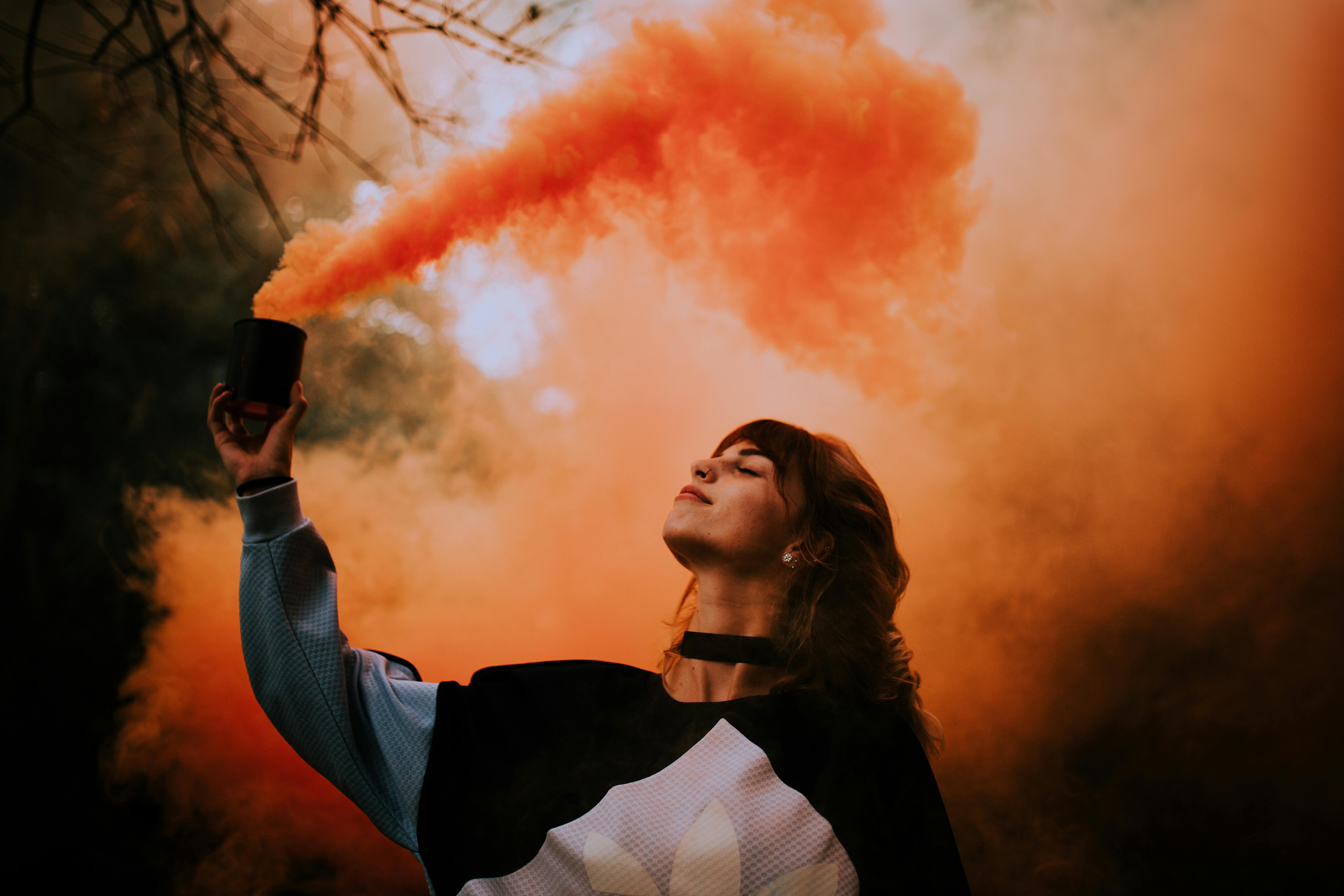 Hand Holding A Pair Of Smoke Bombs by Stocksy Contributor Amy