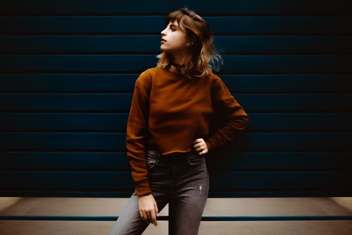 Free Stylish young woman posing confidently against a modern dark backdrop. Stock Photo