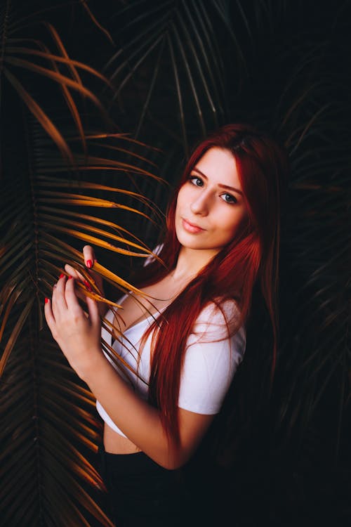 Woman in Crop Top Standing Near Palm Leaves