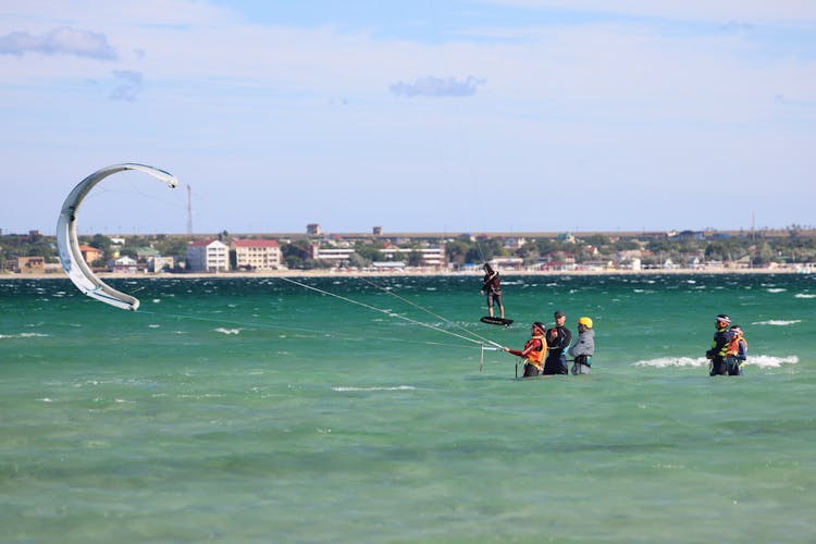 People Paragliding From A Sea Water