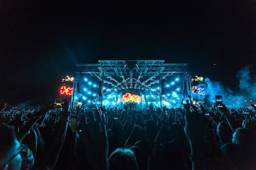 免費 夜間音樂會期間，人群擠在藍色和橙色的舞台前 圖庫相片