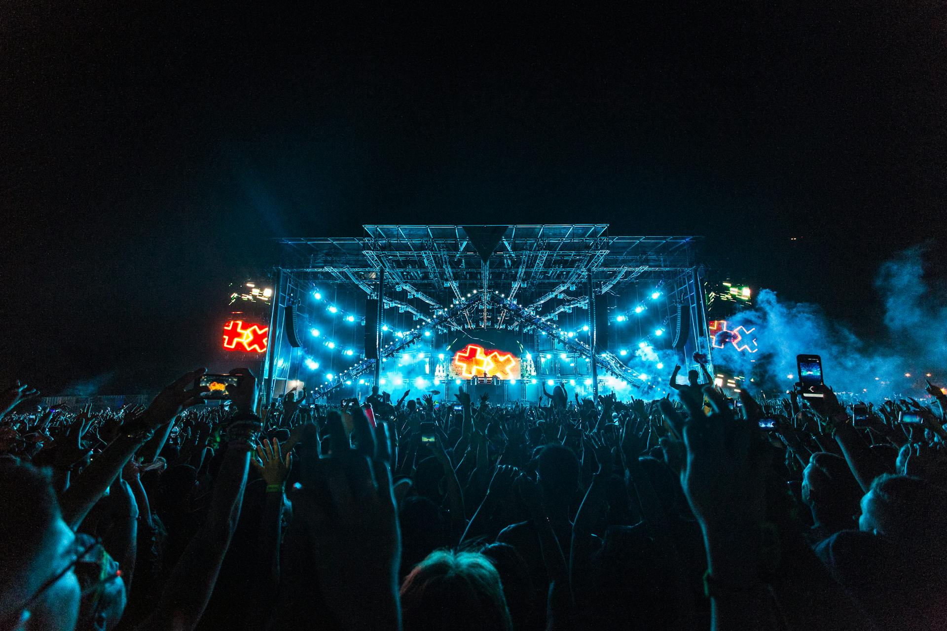 Crowd in Front of Blue and Orange Stage during a Concert at Night