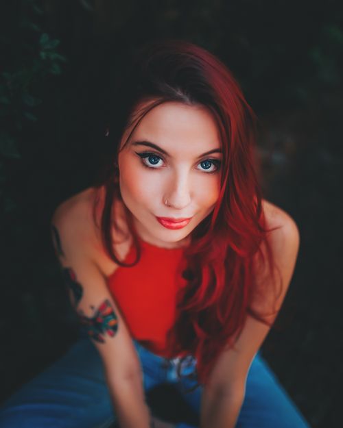 Free Artistic portrait of a woman with red hair and nose piercing in warm tones. Stock Photo