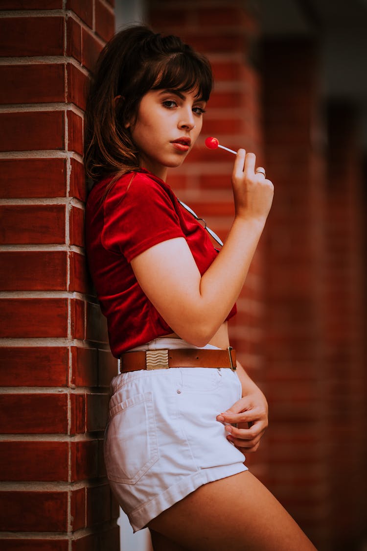 Woman With Lollipop By Wall