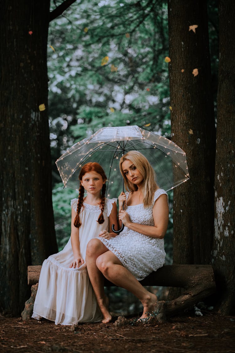 Girl And Woman Under Transparent Umbrella