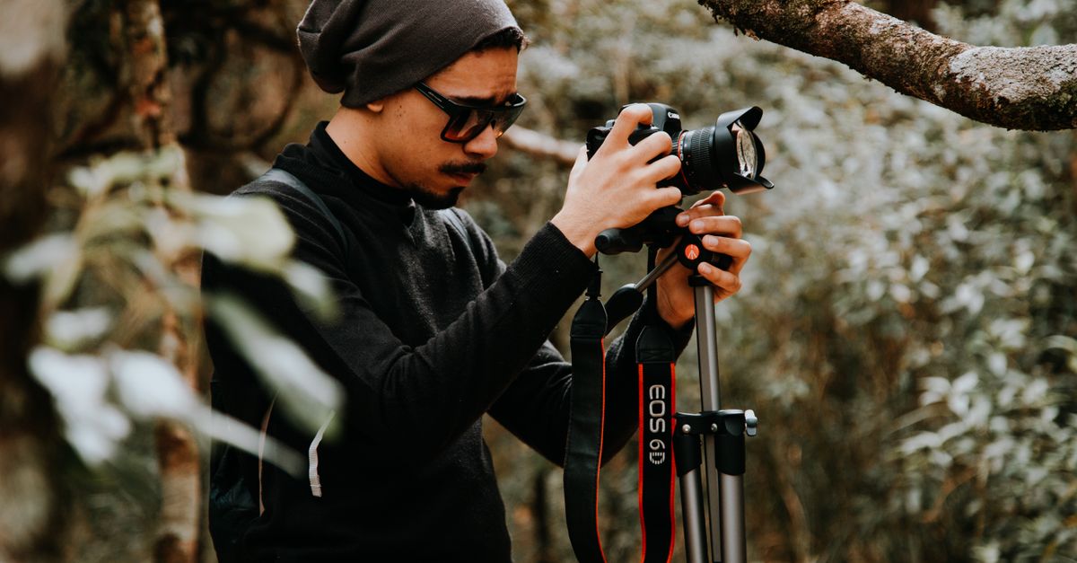Man Setting Image Photograph of a Man Setting Up a Camera · Free Stock Photo