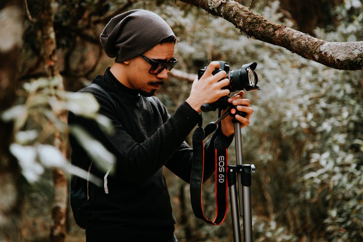 Photograph Of A Man Setting Up A Camera