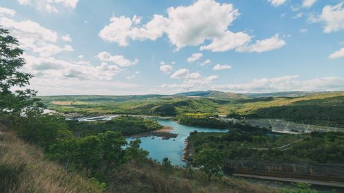 Free Scenic view of a lush river valley with clouds and hills under a clear sky, ideal for travel inspiration. Stock Photo