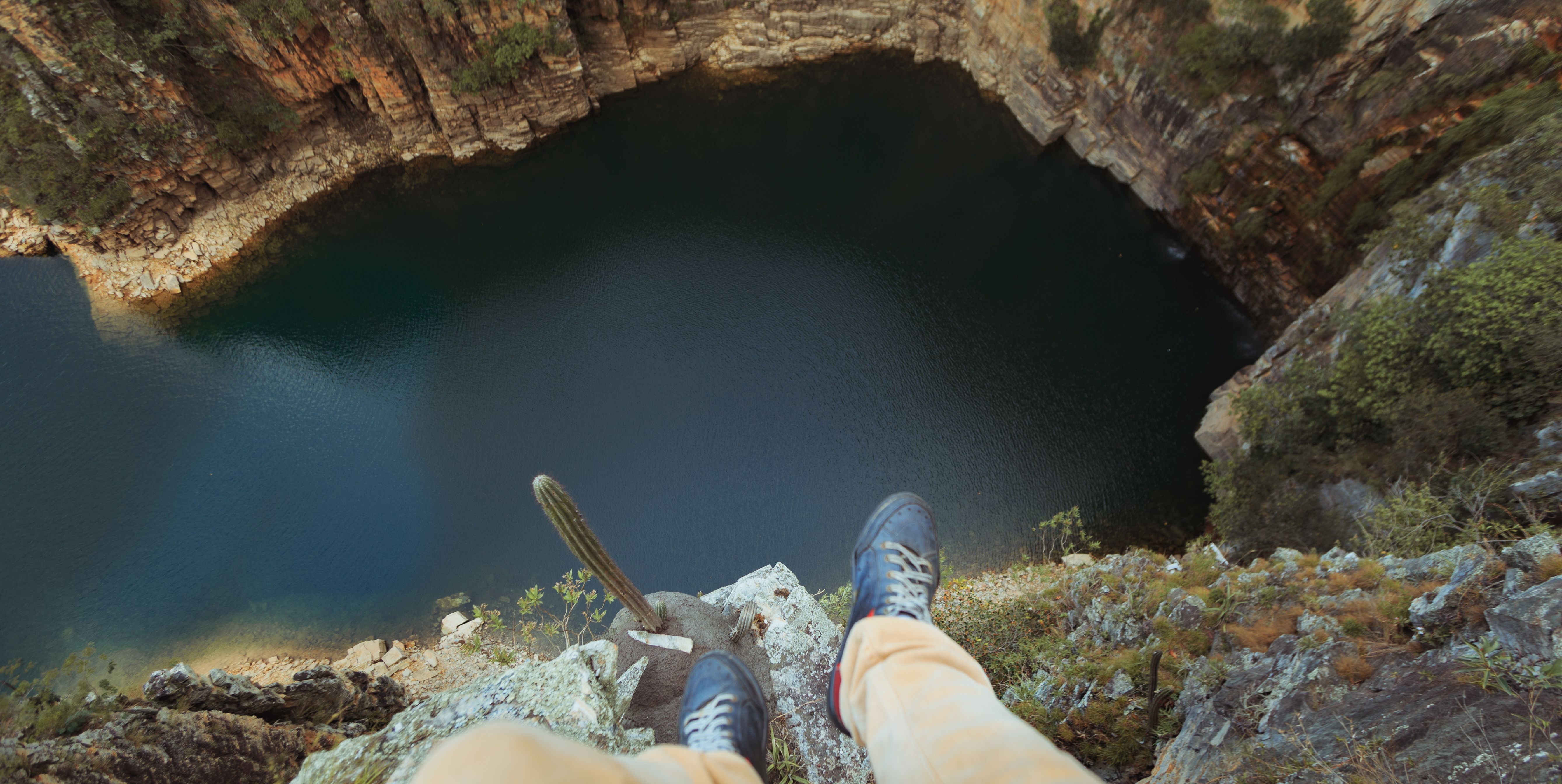 View from a cliff edge overlooking a tranquil lake, capturing adventurous spirit.